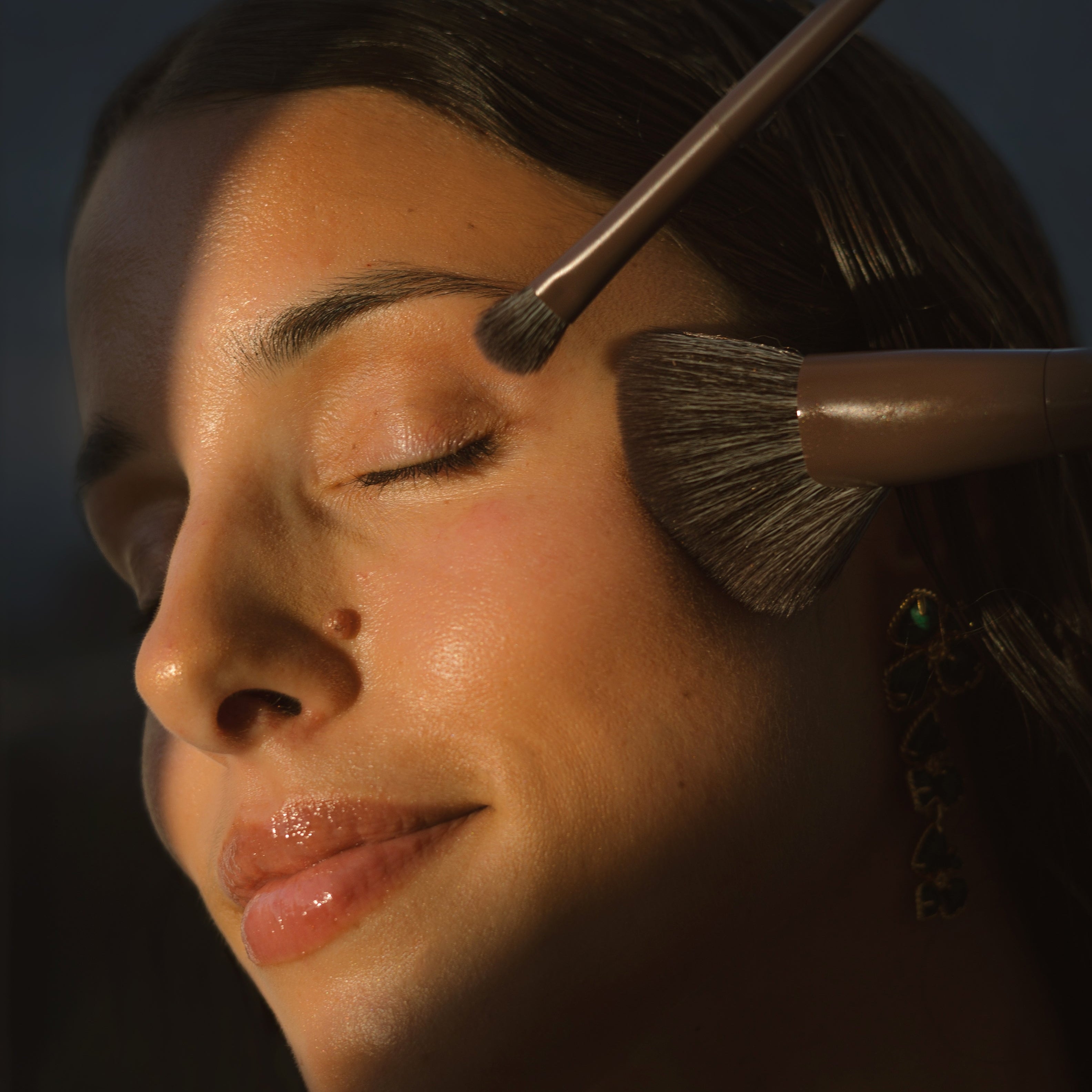 Close-up of a woman's face using 2 of the Eco By Sonya Makeup Brushes.