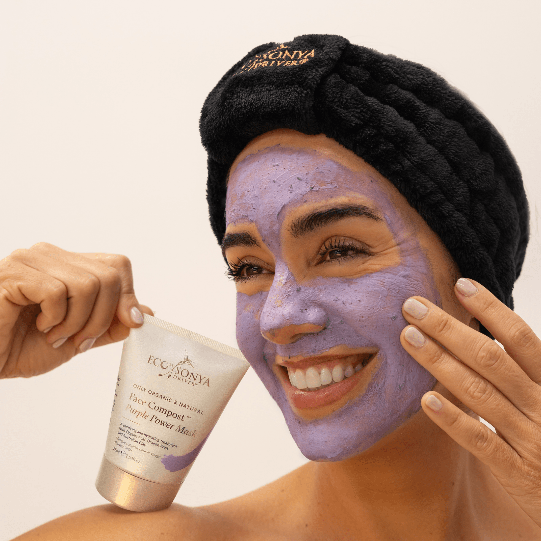 Woman applying purple power  face mask with black velvet elastic headband